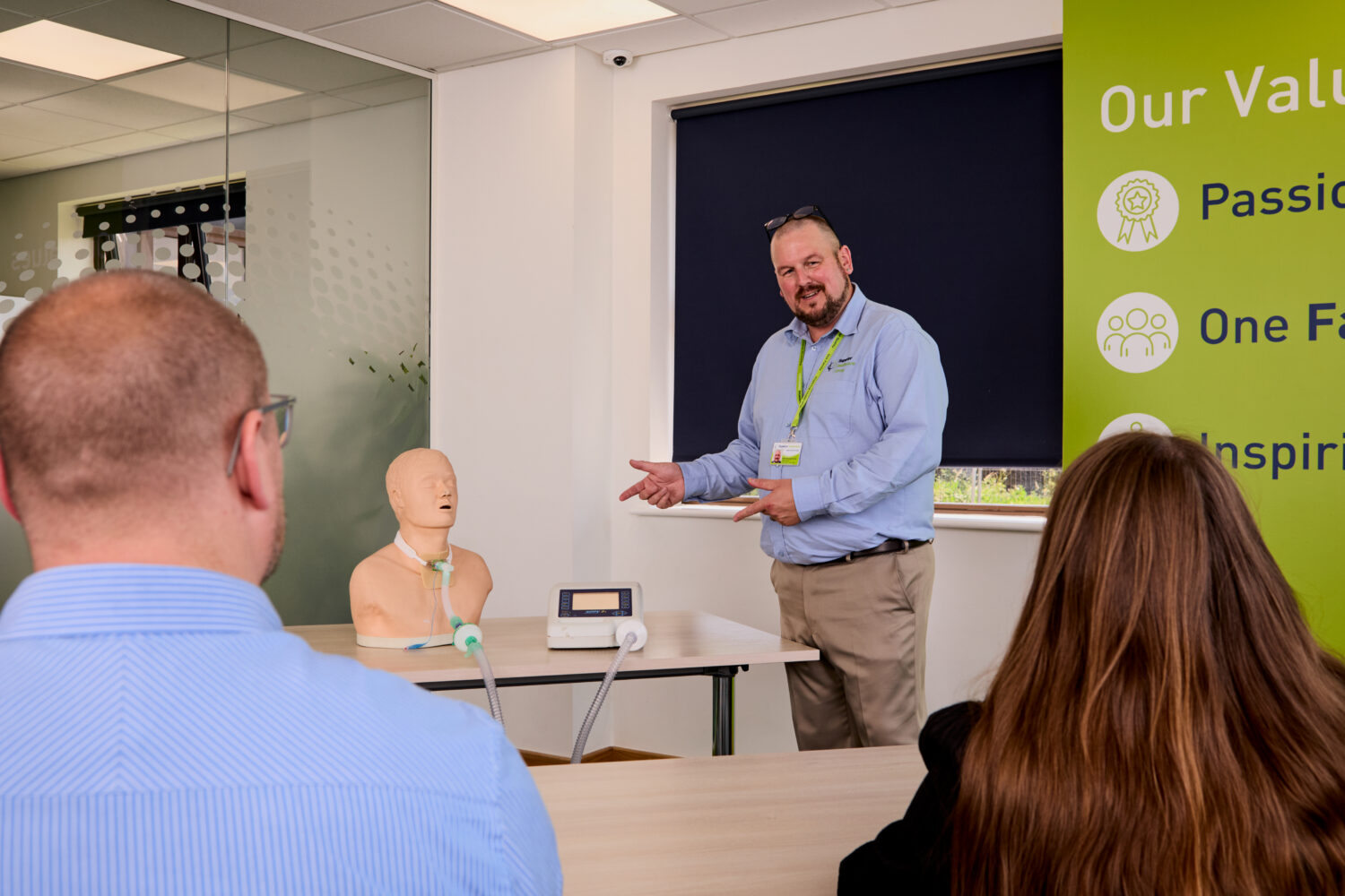 Image of one of our trainers on the Ventilation and Cough Assist Awareness training course showing dummy equipment to attendees.