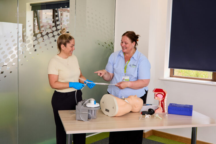 Image of one of our trainers on the Adult and Paediatric Tracheostomy Awareness training course engaging with an attendee.